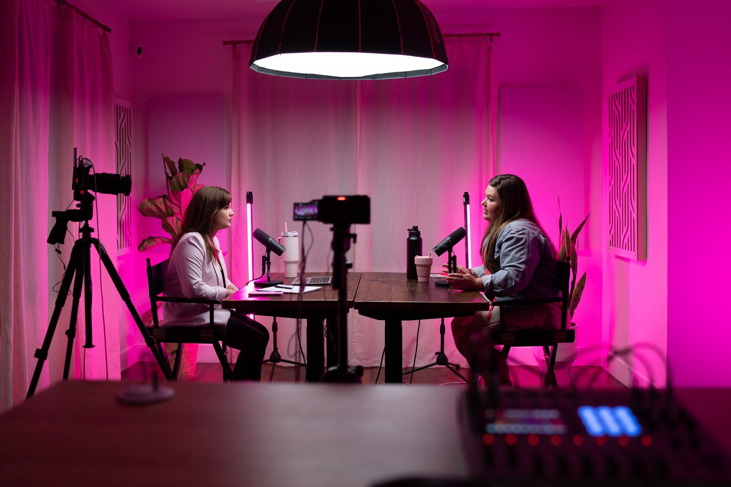 two women recording a podcast across a table